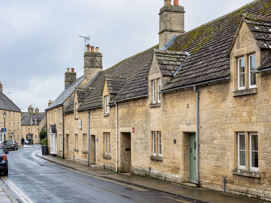 A Cotswold town street of limestone houses with stone tile roofs