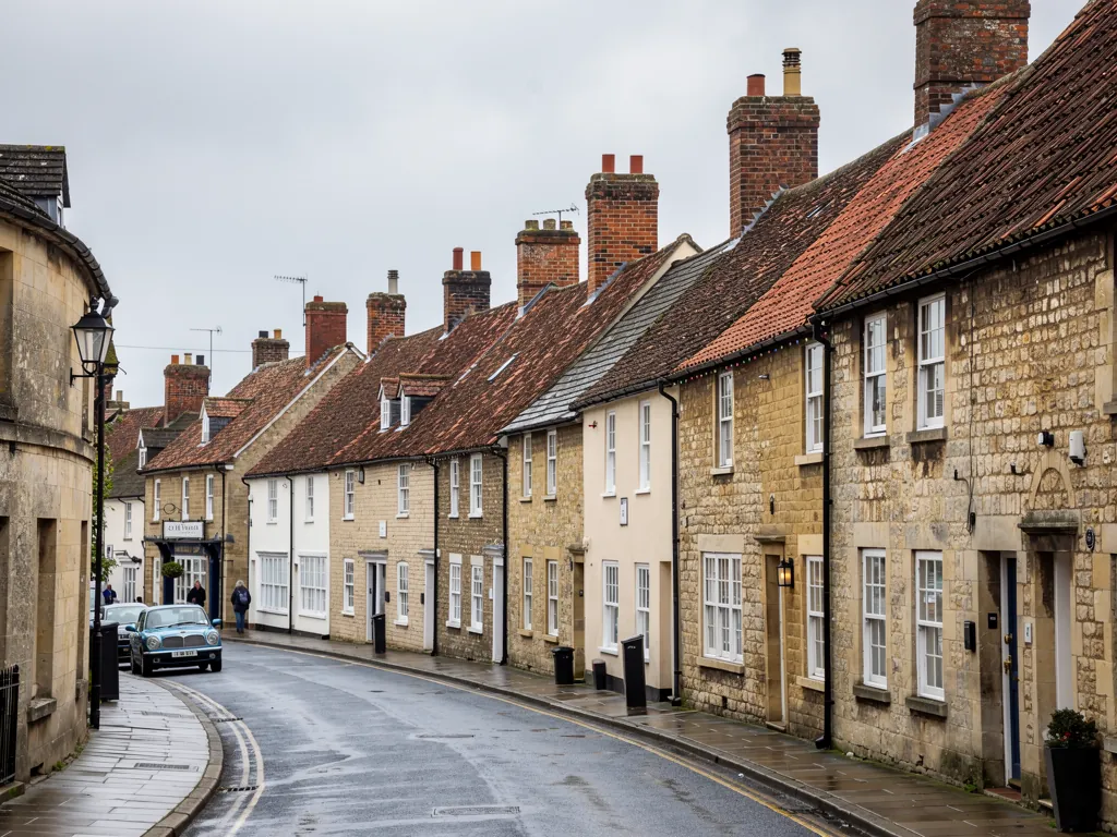 A Wiltshire market town street with stone and brick houses and clay tile roofs